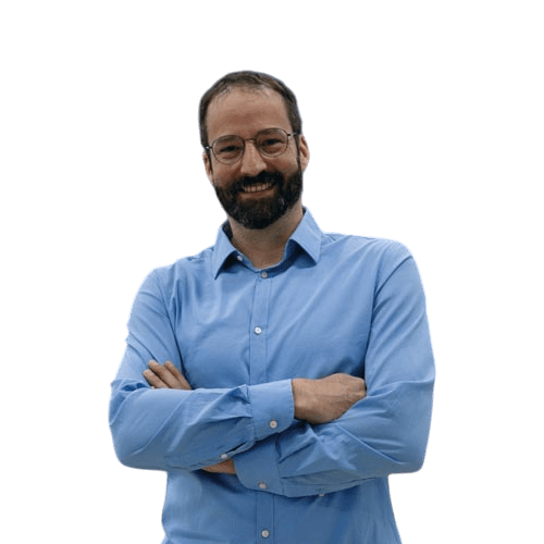 Das Bild zeigt einen lächelnden Mann mittleren Alters mit Brille und Bart. 
                    Er trägt ein hellblaues Hemd und hat die Arme verschränkt. Der Mann hat ein offenen, 
                    freundlichen Gesichtsausdruck und vermittelt einen sympathischen Eindruck.
